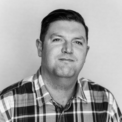 A black and white photo of a man smiling.